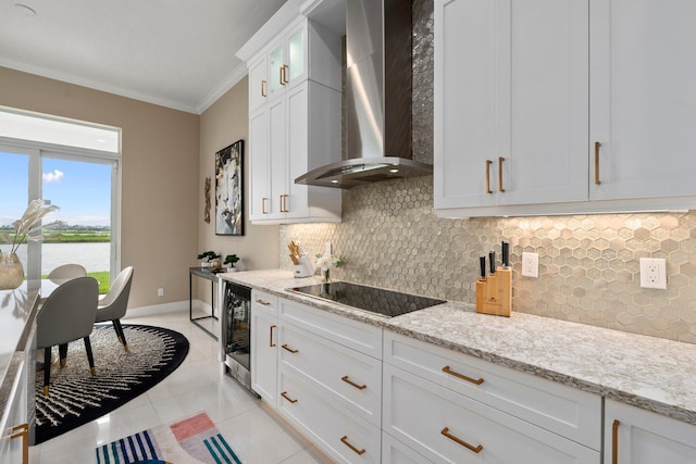 8650 SW Felicita Way, Port Saint Lucie, FL 34987 - kitchen with wall chimney exhaust hood, wine cooler, crown molding, black electric stovetop, and backsplash