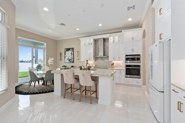 8650 SW Felicita Way, Port Saint Lucie, FL 34987 - kitchen with freestanding refrigerator, wall chimney range hood, crown molding, tasteful backsplash, and a water view