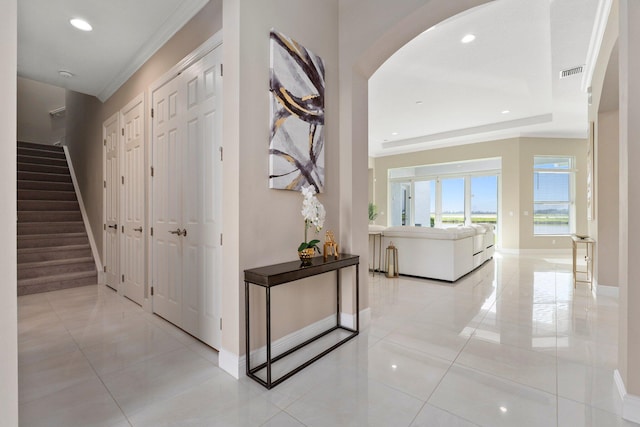 8650 SW Felicita Way, Port Saint Lucie, FL 34987 - hallway with arched walkways, crown molding, light tile patterned flooring, stairs, and recessed lighting