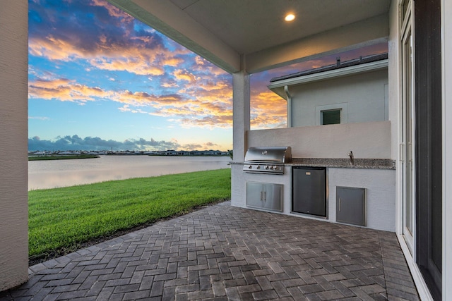 8650 SW Felicita Way, Port Saint Lucie, FL 34987 - patio terrace at dusk with a water view, area for grilling, a patio, and a lawn