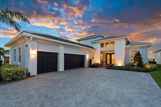 8650 SW Felicita Way, Port Saint Lucie, FL 34987 - view of front of property with an attached garage, decorative driveway, a tile roof, and stucco siding