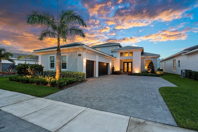 8650 SW Felicita Way, Port Saint Lucie, FL 34987 - prairie-style home featuring an attached garage, driveway, french doors, a yard, and stucco siding