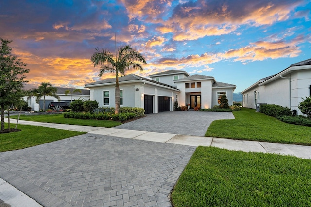 8650 SW Felicita Way, Port Saint Lucie, FL 34987 - view of front of property featuring a garage, decorative driveway, a yard, french doors, and stucco siding