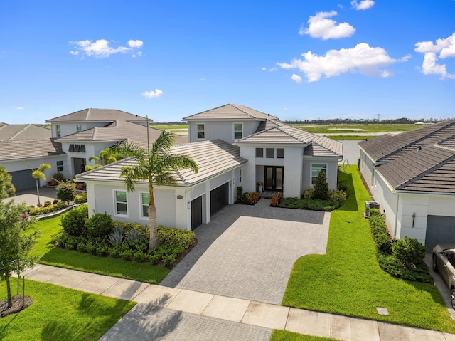8650 SW Felicita Way, Port Saint Lucie, FL 34987 - view of front facade featuring a garage, decorative driveway, a tile roof, and stucco siding