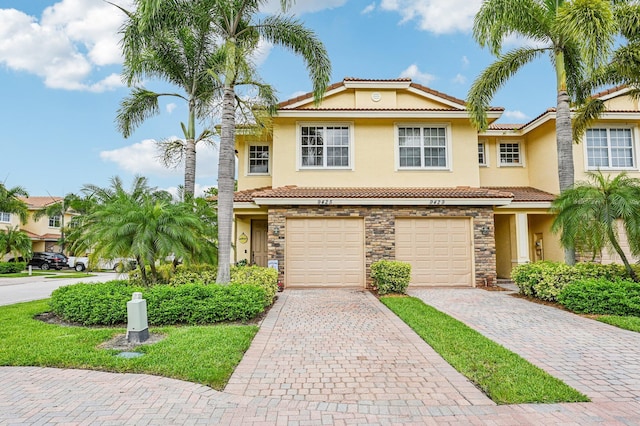 9425 SW Purple Martin Way, Stuart, FL 34997 - view of property featuring stucco siding, a tiled roof, driveway, stone siding, and an attached garage