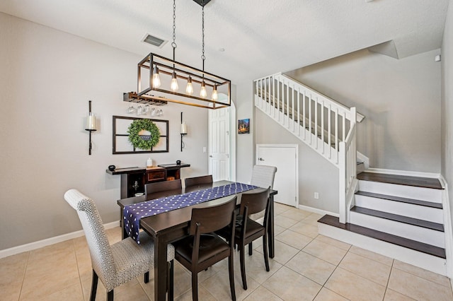 9425 SW Purple Martin Way, Stuart, FL 34997 - dining space featuring light tile patterned flooring, stairs, and a textured ceiling