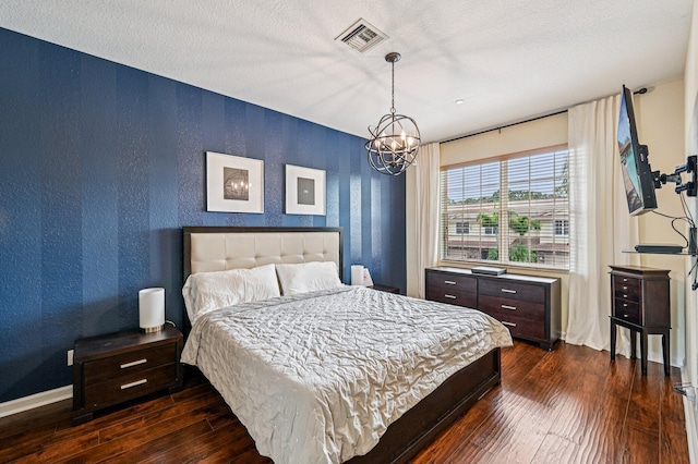 9425 SW Purple Martin Way, Stuart, FL 34997 - bedroom with dark wood-style floors, a chandelier, and a textured ceiling