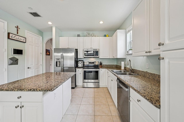 9425 SW Purple Martin Way, Stuart, FL 34997 - kitchen featuring stainless steel appliances, arched walkways, white cabinetry, recessed lighting, and dark stone countertops