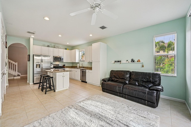 9425 SW Purple Martin Way, Stuart, FL 34997 - living room with arched walkways, light tile patterned flooring, a ceiling fan, recessed lighting, and stairway
