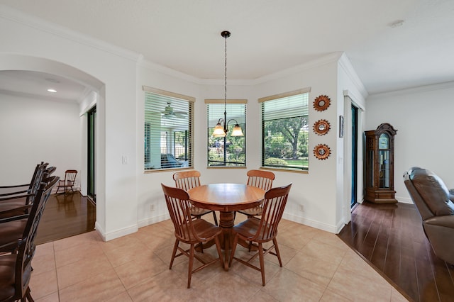 5857 NW Leghorn Ave, Port Saint Lucie, FL 34986 - dining room with healthy amount of natural light, arched walkways, crown molding, and light tile patterned floors