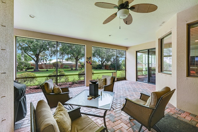 5857 NW Leghorn Ave, Port Saint Lucie, FL 34986 - sunroom with a textured wall, brick flooring, a ceiling fan, and outdoor lounge area