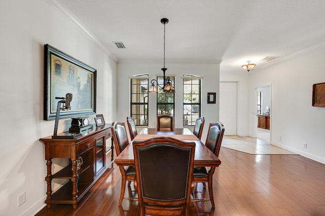 5857 NW Leghorn Ave, Port Saint Lucie, FL 34986 - dining space featuring ornamental molding, hardwood / wood-style flooring, and a chandelier