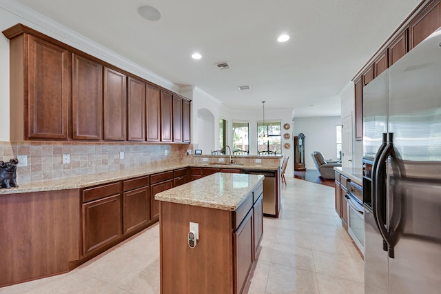 5857 NW Leghorn Ave, Port Saint Lucie, FL 34986 - kitchen with stainless steel appliances, a peninsula, backsplash, light stone countertops, and light tile patterned floors