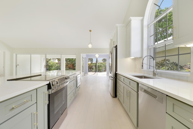 1365 Wilderness Rd, West Palm Beach, FL 33409 - kitchen featuring stainless steel appliances, light countertops, hanging light fixtures, vaulted ceiling, and gray cabinets