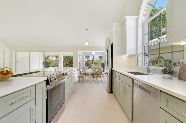 1365 Wilderness Rd, West Palm Beach, FL 33409 - kitchen with appliances with stainless steel finishes, light countertops, hanging light fixtures, and lofted ceiling