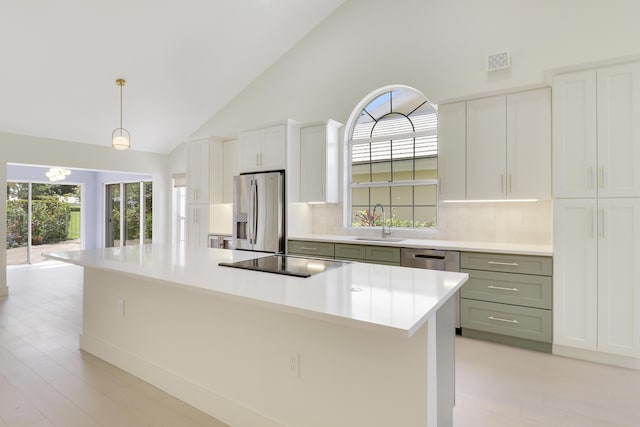 1365 Wilderness Rd, West Palm Beach, FL 33409 - kitchen featuring stainless steel appliances, tasteful backsplash, high vaulted ceiling, light countertops, and light wood finished floors