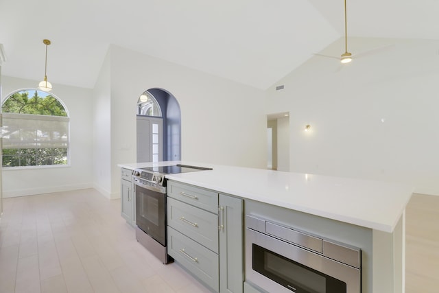 1365 Wilderness Rd, West Palm Beach, FL 33409 - kitchen with stainless steel appliances, gray cabinetry, light countertops, hanging light fixtures, and arched walkways