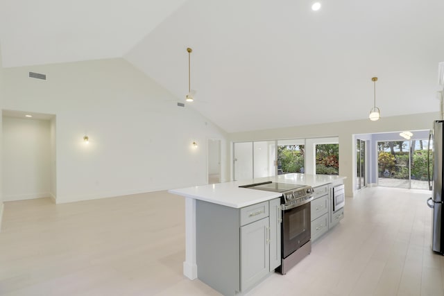 1365 Wilderness Rd, West Palm Beach, FL 33409 - kitchen with appliances with stainless steel finishes, open floor plan, high vaulted ceiling, a center island, and light countertops
