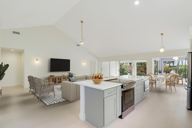 1365 Wilderness Rd, West Palm Beach, FL 33409 - kitchen featuring appliances with stainless steel finishes, high vaulted ceiling, light countertops, a kitchen island, and decorative light fixtures