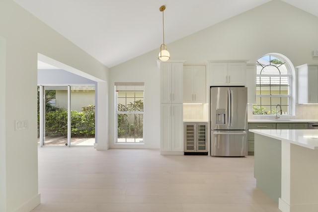 1365 Wilderness Rd, West Palm Beach, FL 33409 - kitchen featuring stainless steel refrigerator with ice dispenser, wine cooler, light countertops, decorative light fixtures, and decorative backsplash