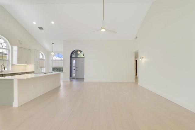 1365 Wilderness Rd, West Palm Beach, FL 33409 - kitchen featuring high vaulted ceiling, light countertops, white cabinets, light wood-type flooring, and a kitchen island