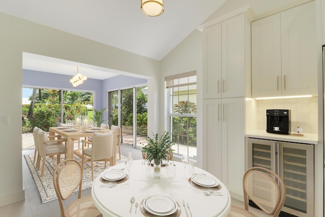 1365 Wilderness Rd, West Palm Beach, FL 33409 - dining area with beverage cooler, lofted ceiling, light tile patterned floors, and a chandelier