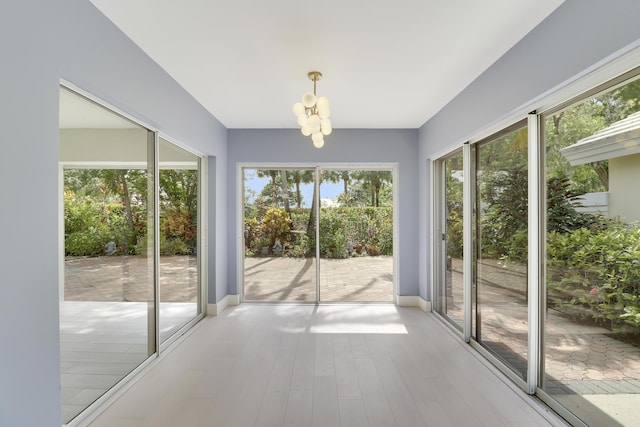 1365 Wilderness Rd, West Palm Beach, FL 33409 - unfurnished sunroom featuring a chandelier and wood finished floors