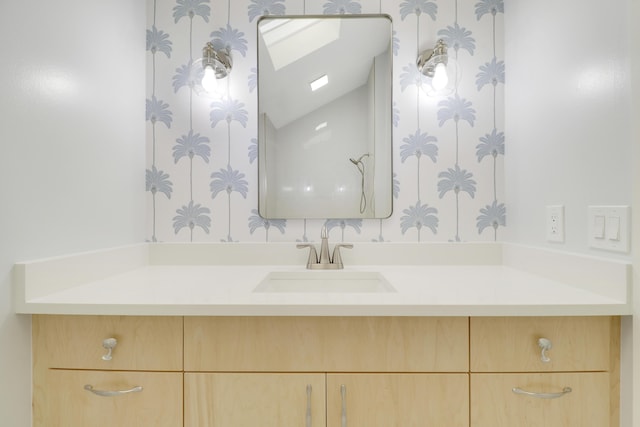 1365 Wilderness Rd, West Palm Beach, FL 33409 - bathroom with vanity, lofted ceiling, and wallpapered walls