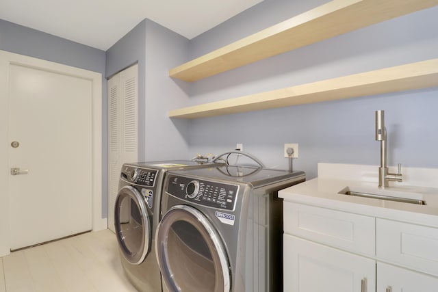 1365 Wilderness Rd, West Palm Beach, FL 33409 - washroom featuring cabinet space, independent washer and dryer, and light wood-type flooring