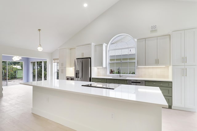 1365 Wilderness Rd, West Palm Beach, FL 33409 - kitchen featuring stainless steel fridge with ice dispenser, cooktop, tasteful backsplash, high vaulted ceiling, and light countertops