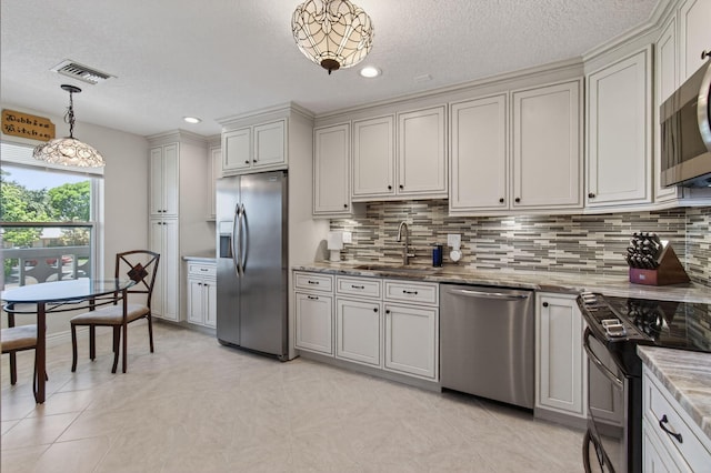 1320 NW 20th Ave Unit 202, Delray Beach, FL 33445 - kitchen featuring stainless steel appliances, backsplash, a textured ceiling, pendant lighting, and light stone countertops