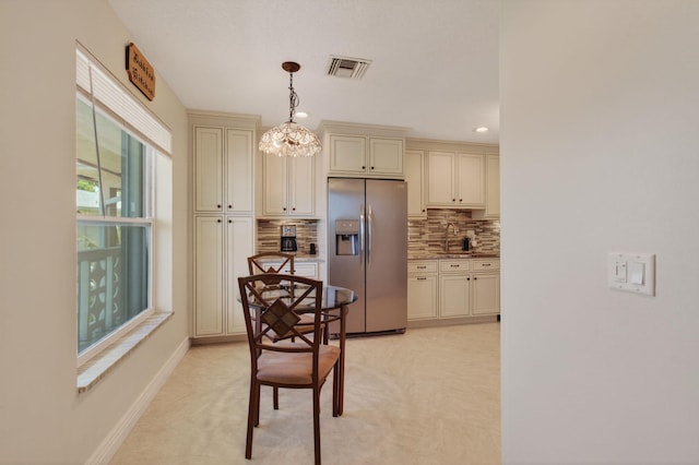 1320 NW 20th Ave Unit 202, Delray Beach, FL 33445 - kitchen featuring stainless steel refrigerator with ice dispenser, cream cabinets, decorative backsplash, hanging light fixtures, and recessed lighting
