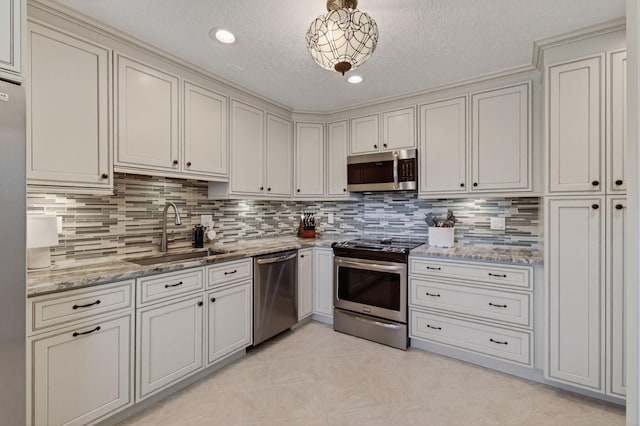 1320 NW 20th Ave Unit 202, Delray Beach, FL 33445 - kitchen featuring stainless steel appliances, light tile patterned flooring, tasteful backsplash, light stone countertops, and a textured ceiling