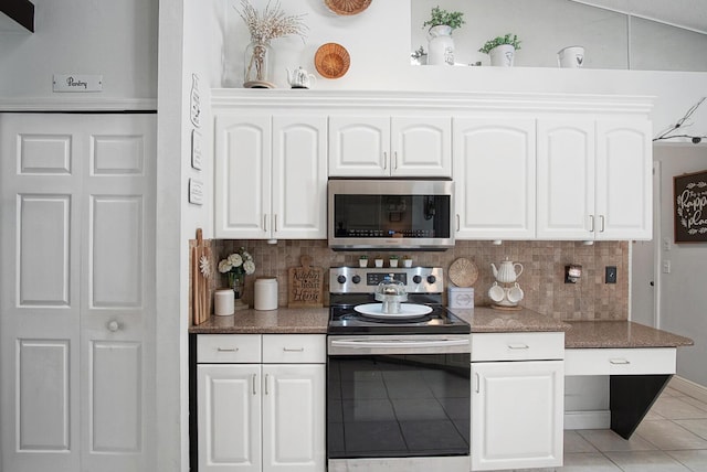 3283 SE W Snow Rd, Port Saint Lucie, FL 34984 - kitchen featuring stainless steel appliances, light tile patterned flooring, backsplash, and white cabinets