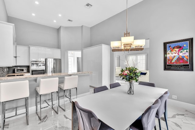 20677 NW 26th Ct, Boca Raton, FL 33434 - dining area with high vaulted ceiling, light marble finish flooring, baseboards, a chandelier, and recessed lighting