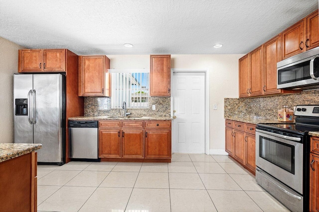 1209 N Australian Ave, West Palm Beach, FL 33401 - kitchen with appliances with stainless steel finishes, brown cabinets, tasteful backsplash, a textured ceiling, and recessed lighting