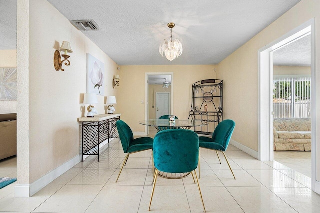 1209 N Australian Ave, West Palm Beach, FL 33401 - dining space featuring a chandelier, a textured ceiling, and tile patterned flooring