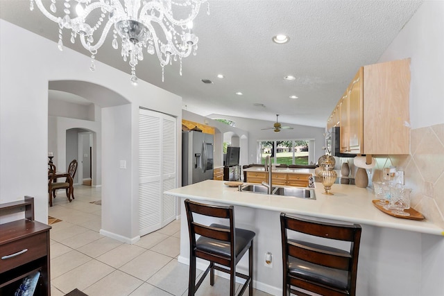 8073 Pelican Harbour Dr, Lake Worth, FL 33467 - kitchen with arched walkways, stainless steel fridge, ceiling fan, a peninsula, and a textured ceiling
