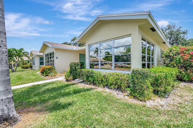5073 Lakefront Blvd Unit D, Delray Beach, FL 33484 - view of side of home with stucco siding and a lawn