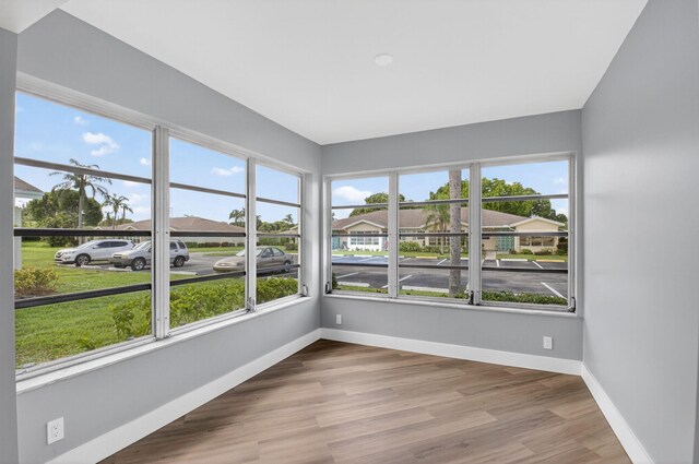 5073 Lakefront Blvd Unit D, Delray Beach, FL 33484 - unfurnished sunroom with plenty of natural light, wood finished floors, and a residential view