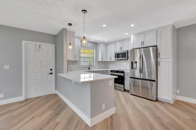 5073 Lakefront Blvd Unit D, Delray Beach, FL 33484 - kitchen with appliances with stainless steel finishes, a peninsula, light wood-style flooring, light countertops, and recessed lighting