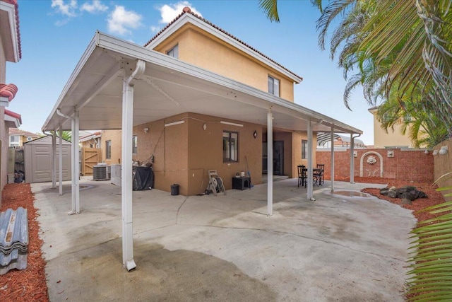 18103 SW 143rd Pl, Miami, FL 33177 - back of property with stucco siding, a storage unit, a fenced backyard, and a patio area