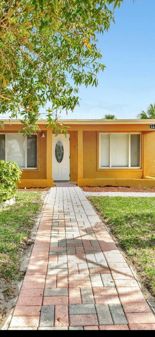 1224 W 31st, Riviera Beach, FL 33404 - property entrance featuring stucco siding and a yard