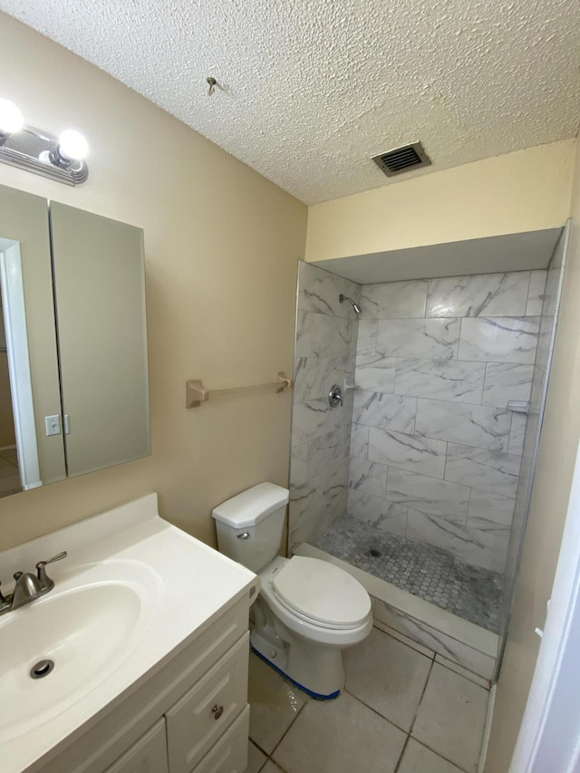 649 SW Heather St, Port Saint Lucie, FL 34983 - bathroom featuring vanity, tiled shower, a textured ceiling, toilet, and tile patterned floors