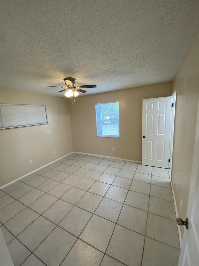 649 SW Heather St, Port Saint Lucie, FL 34983 - unfurnished room with a textured ceiling, light tile patterned flooring, a ceiling fan, and baseboards