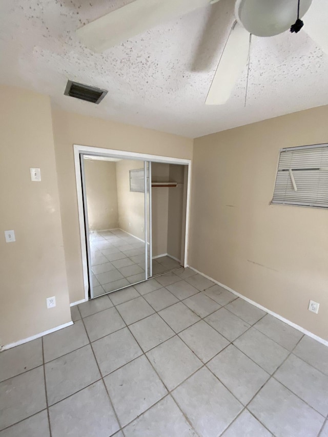 649 SW Heather St, Port Saint Lucie, FL 34983 - unfurnished bedroom featuring light tile patterned floors, a closet, ceiling fan, and baseboards
