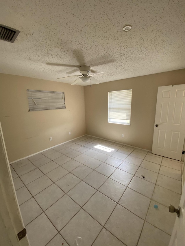 649 SW Heather St, Port Saint Lucie, FL 34983 - spare room featuring light tile patterned floors, a ceiling fan, and a textured ceiling