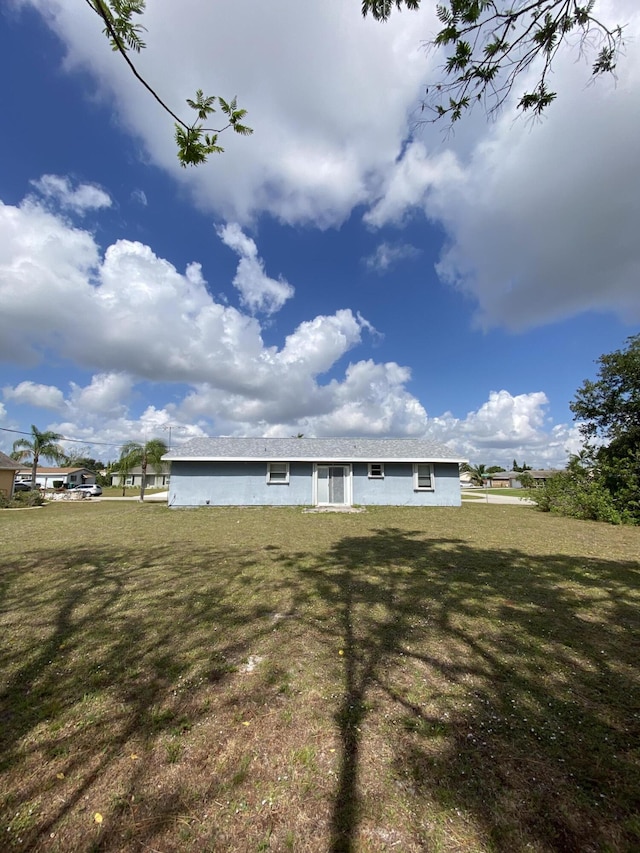 649 SW Heather St, Port Saint Lucie, FL 34983 - back of house featuring a yard