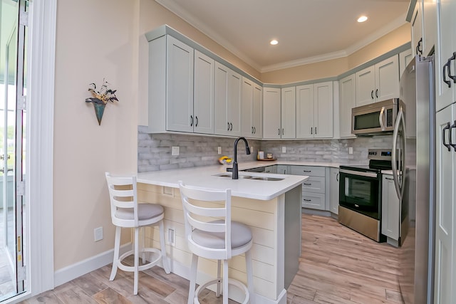 424 NE Leaping Frog Way, Port Saint Lucie, FL 34983 - kitchen with appliances with stainless steel finishes, a sink, crown molding, decorative backsplash, and light countertops