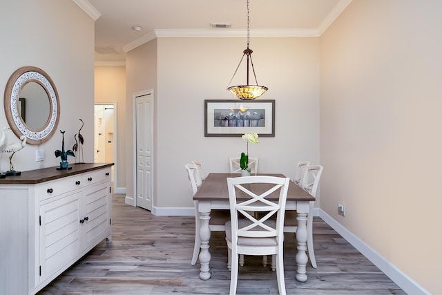 424 NE Leaping Frog Way, Port Saint Lucie, FL 34983 - dining area with crown molding, light wood finished floors, and baseboards